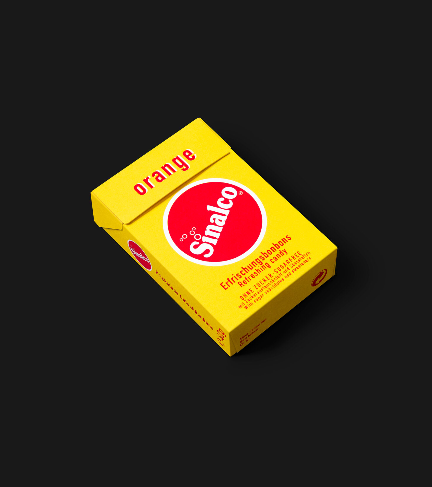 Die gelbe Bonbon-Schachtel liegend auf Schwarzem Hintergrund. Gestaltet von Grafikdesign Cueni Basel.